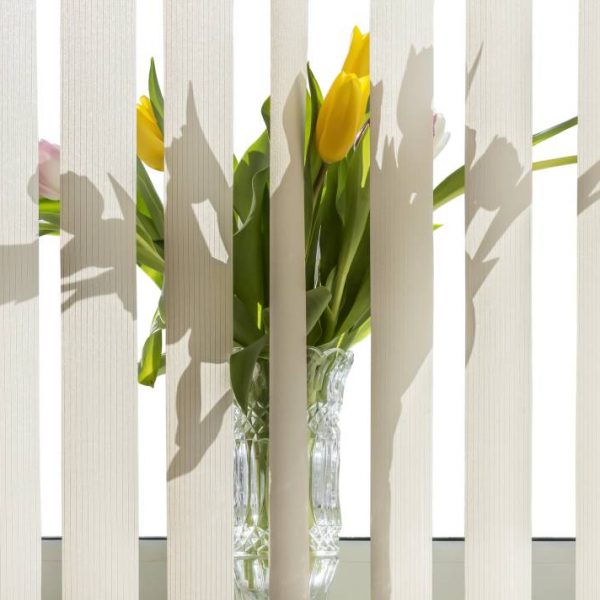 Bouquet of flowers in a vase standing on the windowsill for vertical blinds